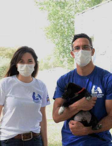 Couple with masks holding dog